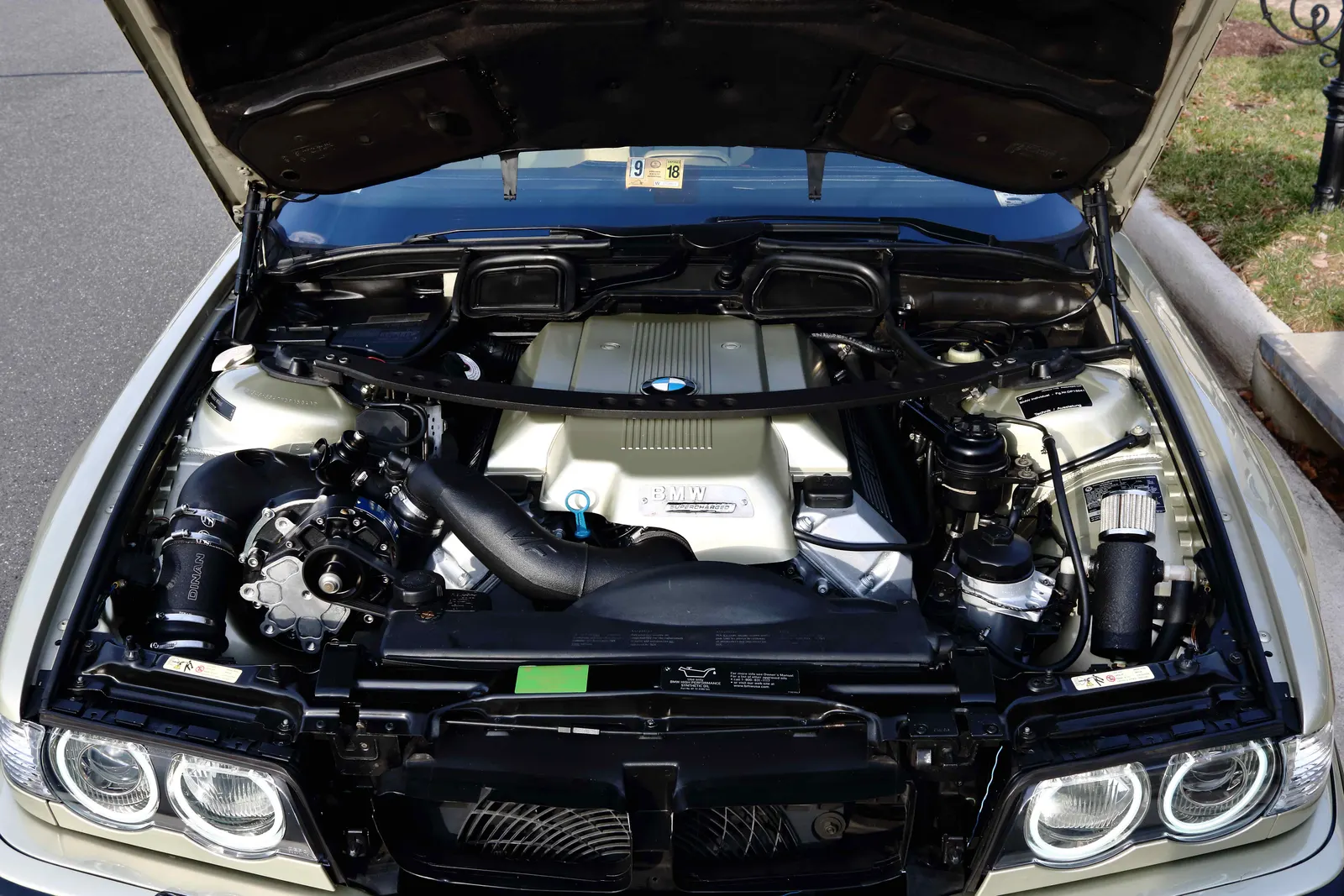 Supercharged BMW E38 V8 engine bay with Dinan intake and strut brace